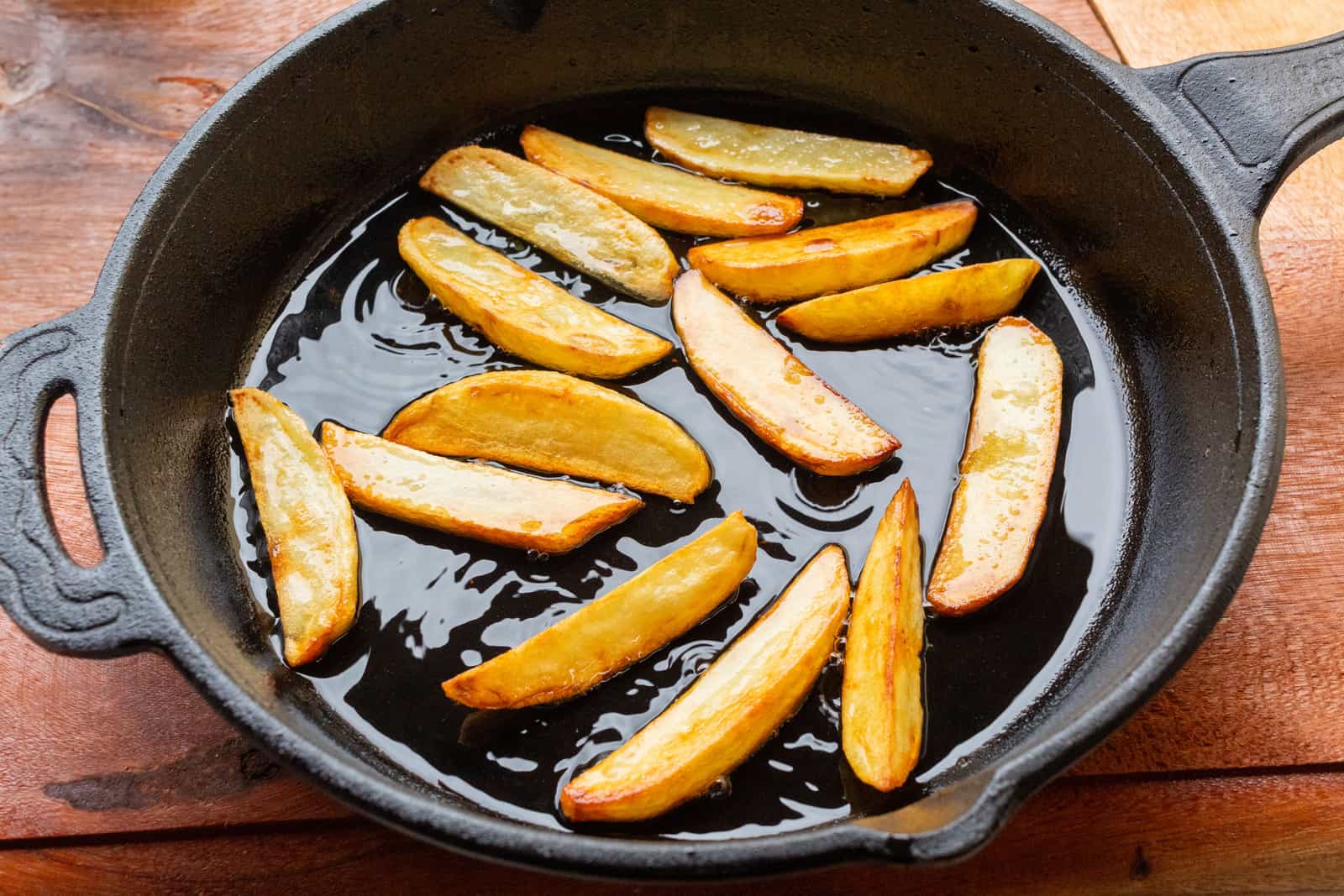 A hand oiling a cast iron skillet to season it