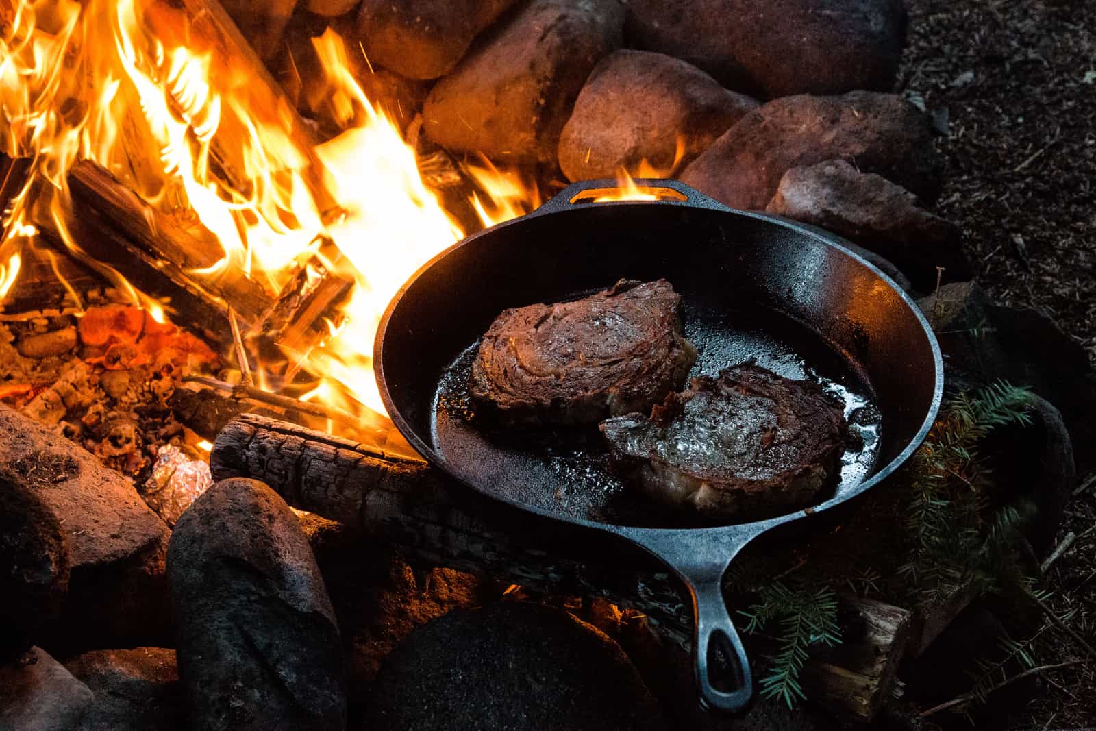 A steak searing in a cast iron skillet